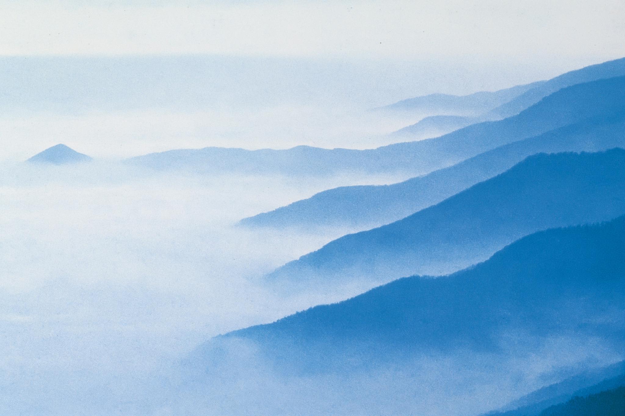 Painting of blue mountain ridges rising out of white mist